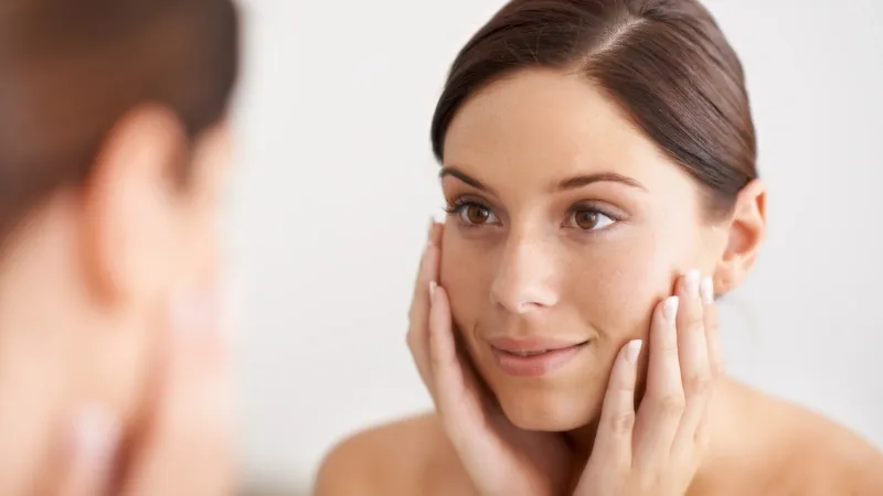Woman looking at her skin.